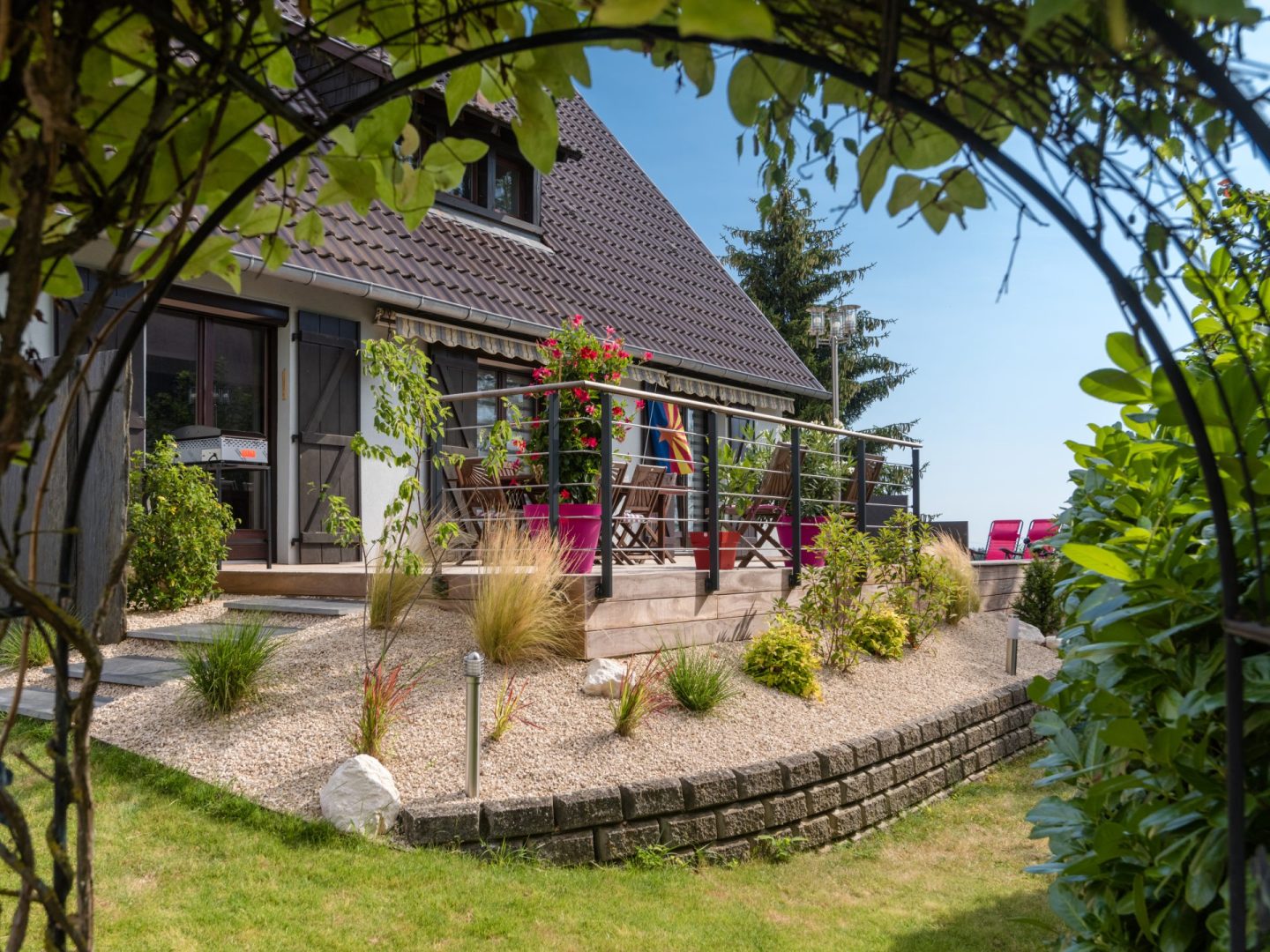 Terrasse en bois et massif paysager devant une maison alsacienne, réalisation LNP Paysage à Strasbourg