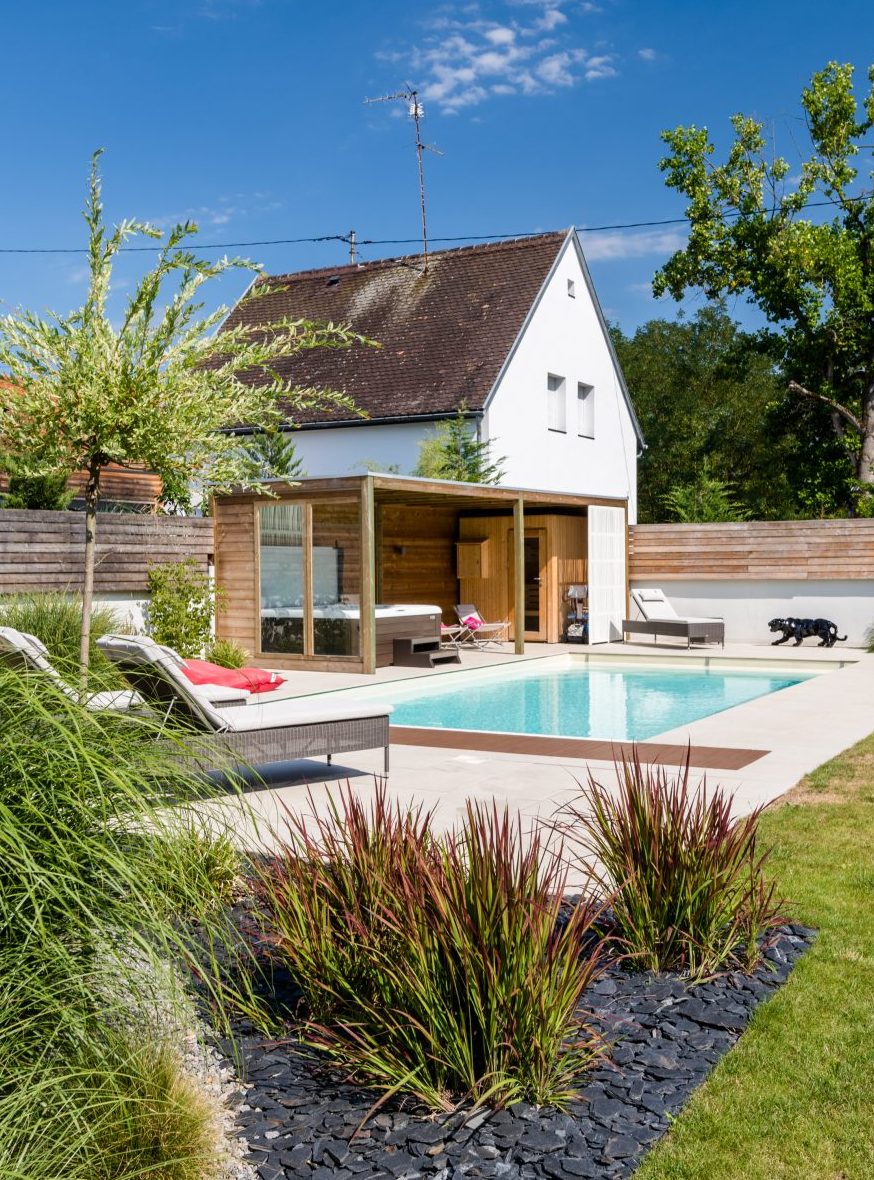 Piscine et pool house en bois intégrés dans un jardin paysager à Molsheim par LNP Paysage